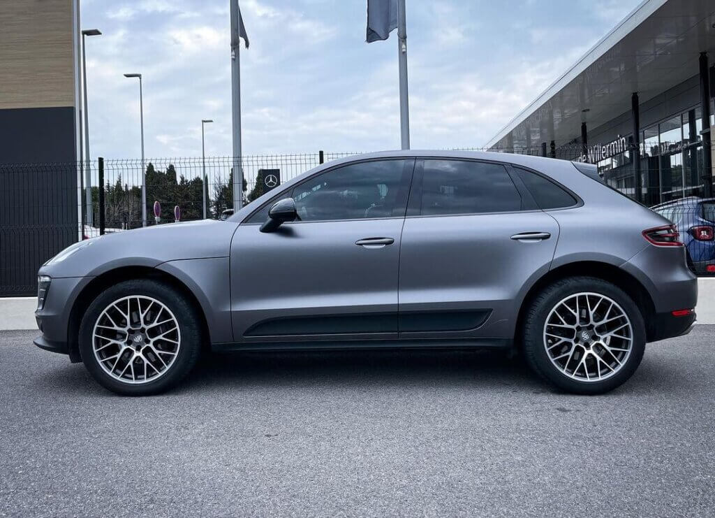 SUV gris stationn&eacute; devant le concessionnaire automobile.